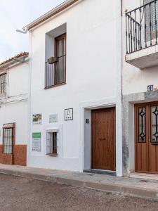 Casa Rural El Palomeque的街道上带木门的白色建筑