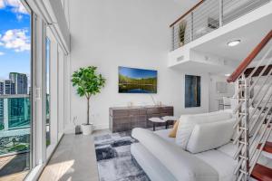 迈阿密Stunning 1 Bedroom Loft in The Heart of Brickell的客厅配有白色家具和大窗户
