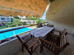新马克立MIRAMARE的一个带游泳池的阳台的一张木桌和椅子
