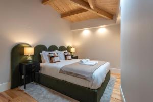 波尔图Ando Living - Flores Townhouse的一间卧室配有一张大床和绿色床头板