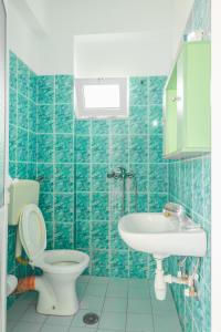 希马拉Rooms by the sea的蓝色瓷砖浴室设有卫生间和水槽