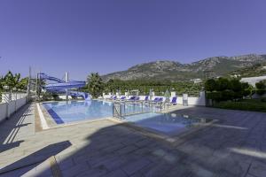 马赫姆拉Residence w Balcony and Shared Pool 7 min to Coast的一个带椅子的游泳池,背景是山脉