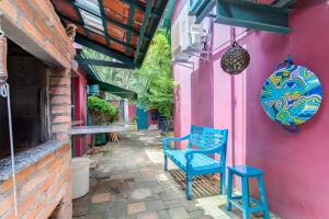 圣保罗Ibirapuera Park House的蓝色长椅,坐在粉红色建筑外面