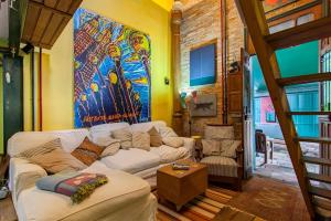 圣保罗Ibirapuera Park House的客厅配有白色沙发和绘画作品