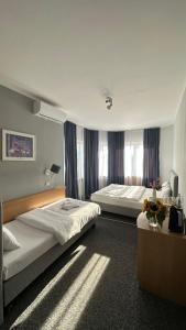 华沙Lezzet Hotel & Turkish Restaurant的酒店客房设有两张床和窗户。