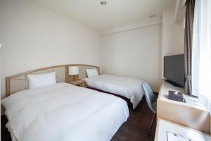 新泻科特新泻酒店的酒店客房设有两张床和电视。