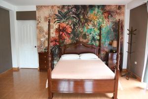Nuevo TingoZoila's Suite Escape的一间卧室配有一张带花卉壁纸的天蓬床
