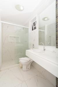 布希奥斯Pousada Marbella Inn的白色的浴室设有卫生间和水槽。