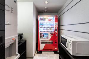 新泻科特新泻酒店的一间配有微波炉的客房内的红色自动售货机