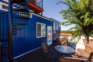 Apple ValleyLil' Blue Oasis Tiny Home的蓝色的房子,甲板上配有桌椅