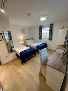 剑桥The Tas Suites - Tas Accommodations的一间设有两张床和一张桌子的房间