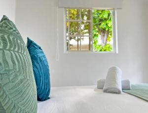 圣安德烈斯Zaba Beach House的客房配有2个蓝色枕头和窗户。