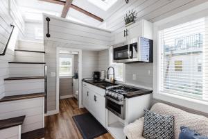 Apple ValleyRoyal sands tiny home的厨房配有白色橱柜和炉灶。