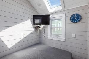 Apple ValleyRoyal sands tiny home的一间设有时钟和窗户的客房