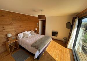 PelluhueHotel Puerto Madera by DOT Boutique的一间卧室配有一张木墙床