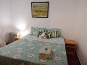 Villa LoncaLa Laurina Casa de Campo Hotel/Hospedaje的一间卧室配有一张带绿色棉被和粉红色鲜花的床。