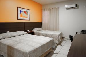 乌贝兰迪亚阿蒂公园酒店的酒店客房设有两张床和一张桌子。