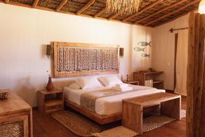 阿廷斯Rancharia Charme Beach - Pé na Areia的一间卧室配有一张大床和木制床头板