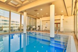 圣地亚哥埃布罗河森林广场酒店的一座带柱子的大建筑中的游泳池