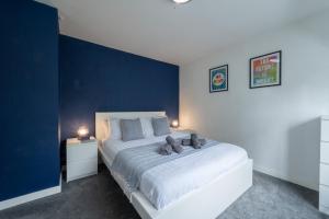 PolesworthSpacious 5-bedroom home perfect for large groups的一间卧室设有一张蓝色墙壁的大床