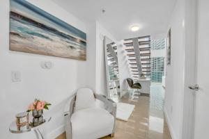 迈阿密Modern 2 Story Loft 2BR with Breathtaking Views的白色的客厅配有白色椅子和桌子