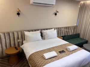 尼夫佐哈PALACE of the Dead Sea by CROWN Exclusive的酒店客房,配有一张床和一把绿色椅子