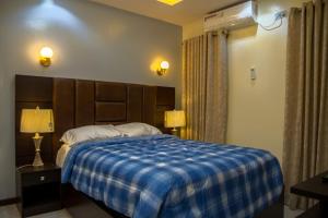伊巴丹Lake Luxury Homes的一间卧室配有一张带蓝色铺面毯子的床