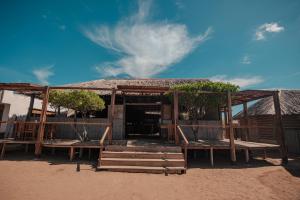 卡波德拉维拉Rancheria Utta的海滩上的小屋,有长椅和树木