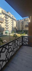 Ouled MoussaAppartement F3 moderne en Résidence的阳台设有黑色栏杆,部分建筑