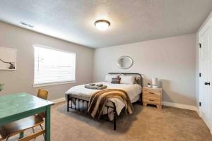 奥勒姆Sleepy Ridge Apt in Vineyard/Orem (Sleeps 6)的一间卧室配有一张床、一张桌子和一个窗户。