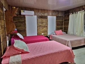 比利亚维哈Tatacoa Star Eco Hotel的一间设有两张粉红色床单的床的房间