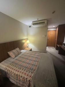 巴西利亚Flat Taguatinga的卧室配有一张床,墙上配有空调