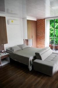 El PedregalCucaña Hotel的一间卧室配有一张大床和一张沙发