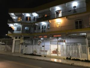奥托兰迪亚Hotel Belo Jardim的一座建筑,在晚上前有栅栏