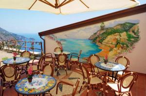 普莱伊亚诺罗坎达德格里德酒店的一间设有桌椅的房间和墙上的绘画