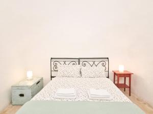 马丁纳弗兰卡Parco della Vigna的白色卧室,配有带2条白色毛巾的床