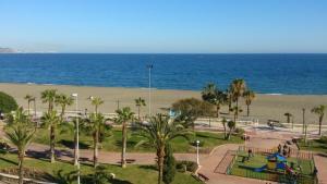 托雷德尔马尔米拉亚海滩酒店的一个带游乐场的公园和一个海滨海滩