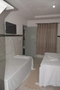 嘎林海斯港Hostel Adriana Alves的酒店客房设有两张床和一台平面电视。