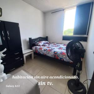 巴耶杜帕尔HABITACION EN APARTAMENTO COMPARTIDO - VENTILADOR的一间卧室设有一张床、一个窗口和风扇