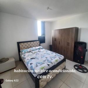 巴耶杜帕尔HABITACION EN APARTAMENTO COMPARTIDO - VENTILADOR的一间卧室配有一张床和一个木制橱柜