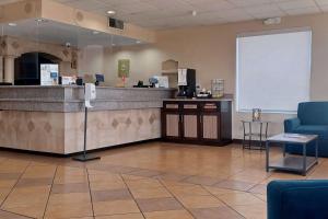 埃尔帕索Quality Inn & Suites Airport的一间设有柜台和白色屏幕的等候室