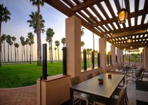 圣巴巴拉圣巴巴拉海滨度假希尔顿酒店的一个带桌椅和棕榈树的庭院