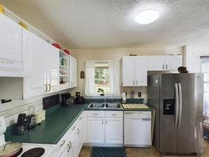 费耶特维尔Pine Forest Zen Cottage - 10 Min to Fort Bragg的厨房配有白色橱柜和不锈钢冰箱