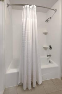 玛丽埃塔市玛丽埃塔市/I-75北州际公路亚特兰大庭院酒店的浴室配有白色的淋浴帘和浴缸。