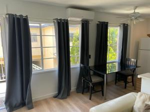 洛杉矶Renovateed Two-Bedroom Apartment in Santa Monica的一间用餐室,配有黑色窗帘和桌子