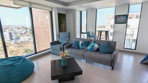 曼塔Departamento vista al mar en Manta Poseidon的带沙发、椅子和窗户的客厅