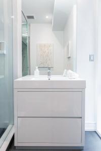 多伦多Elegant Downtown Home的白色的浴室设有水槽和镜子