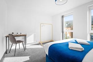 伯明翰Luxury 4 Bed House with En-suite, Games room, BBQ, On-site parking By Azura Nights的一间卧室配有一张床、一张桌子和一把椅子
