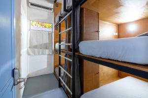 圣塔特蕾莎海滩Akih Pods Hostel的小房间设有两张双层床和窗户