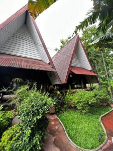 Ban Yang PlaoSoft Resort Kad Farang Hangdong的锡屋顶和小径的房子